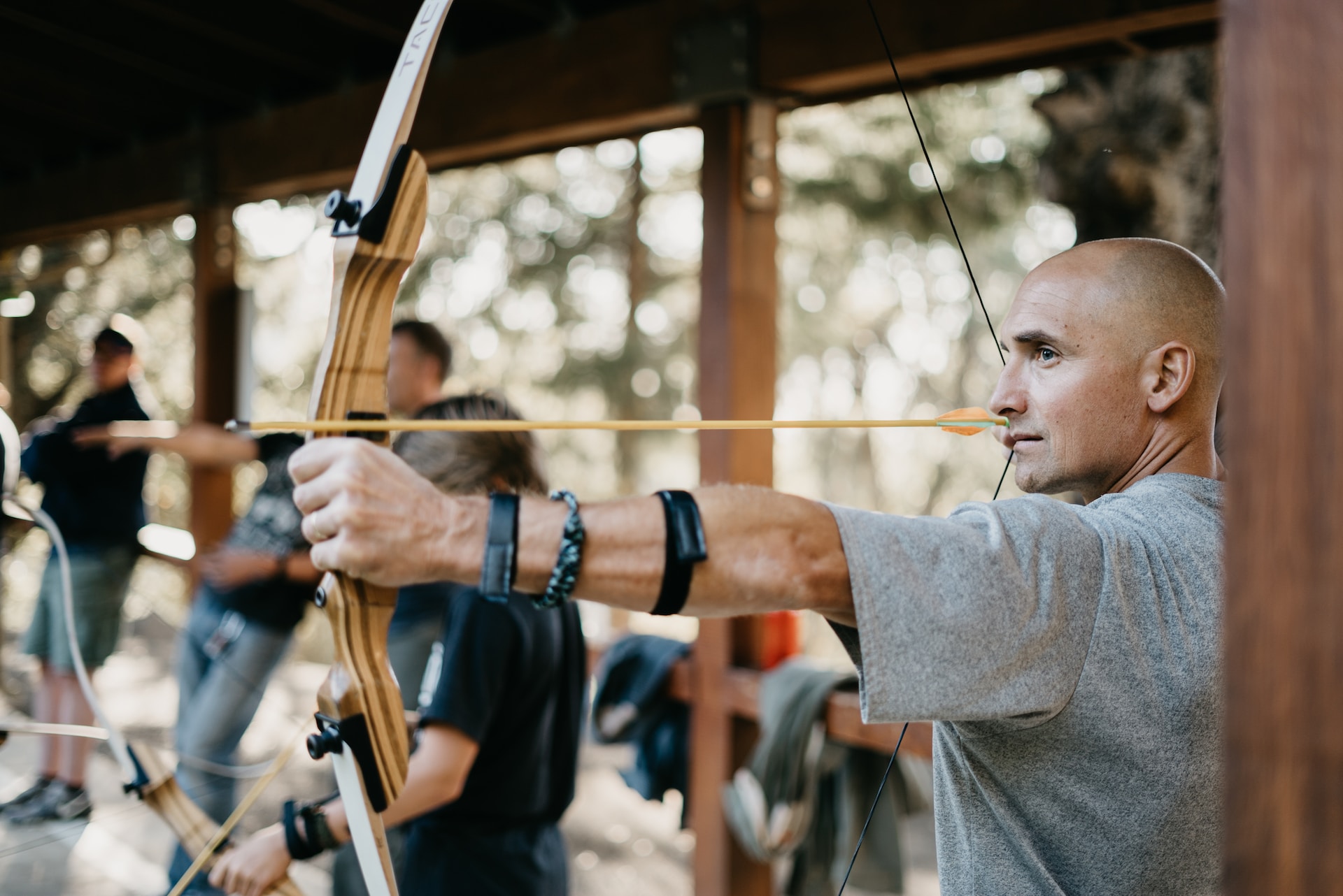 man at archery range aiming a recurve bow
